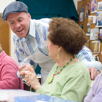 young man discusses beadmaking with resident