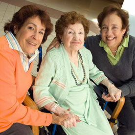 Mother holding hands with two daughters on each side, in the atrium of the Friedman Pavilion