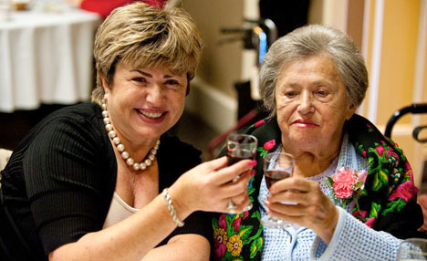 Resident and family member at a birthday luncheon, making a toast