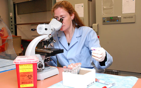 woman using microscope in research lab