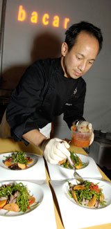 Chef plating dishes, adding a sauce