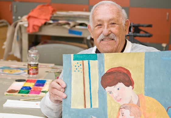 George Ruimy proudly holds up one of the paintings that make up his extensive portfolio. George Ruimy