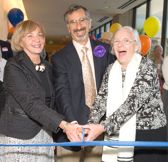 Three community leaders cutting the ribbon at the opening celebration